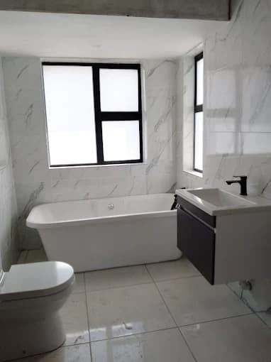 Bathroom renovation with marble-look tiles and freestanding tub